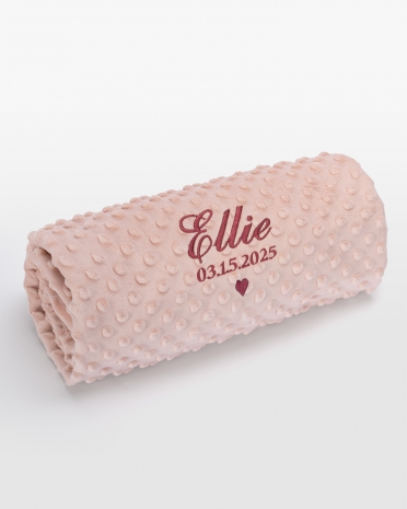 Vaaleanpunainen vauvanpeitto vadelmanvärisellä nimikirjonnalla