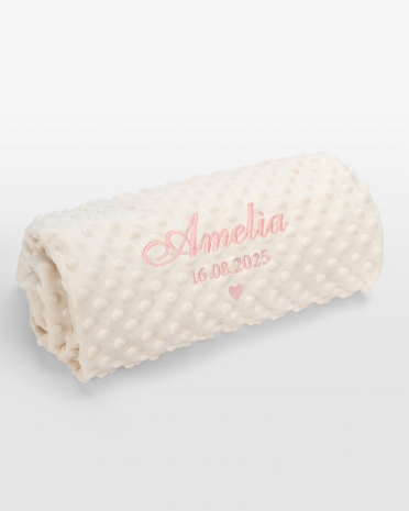 Kermanvärinen vauvanpeitto vaaleanpunaisella nimikirjonnalla