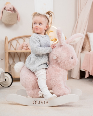 Vaaleanpunainen keinuhevonen pupun muodossa henkilökohtaisella merkinnällä