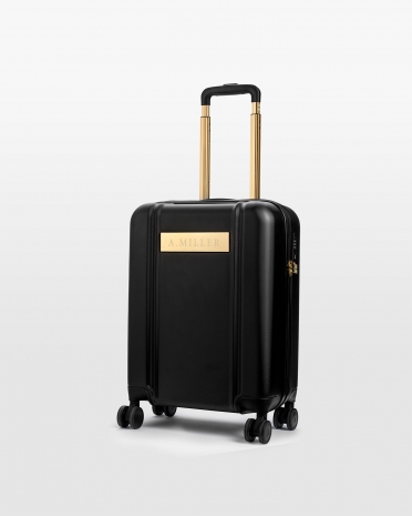 Musta käsimatkatavaralaukku, jossa kaiverrettu nimi ja kultaiset yksityiskohdat