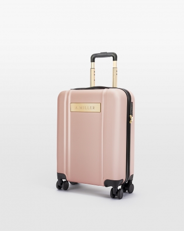 Vaaleanpunainen käsimatkatavaralaukku, jossa on kaiverrettu nimi ja kultaiset yksityiskohdat