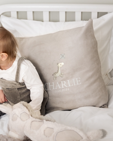 Harmaa samettinen tyynyliina, jossa nimi ja kirahviaihe