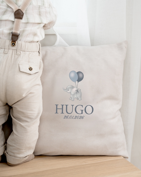 Harmaa tyyny, jossa on norsuaihe sekä nimi ja päivämäärä