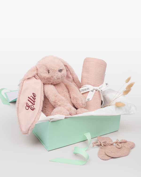 Setti, johon kuuluu nimikoitu pehmopupu, musliinipeitto ja neulotut tossut vastasyntyneelle