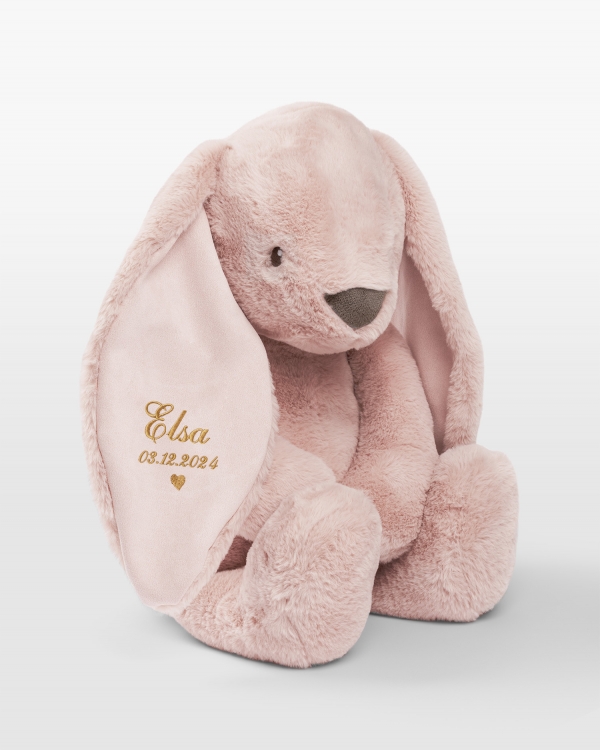 Iso pupu pehmolelu kultakirjonnalla ja nimi sekä syntymäaika.