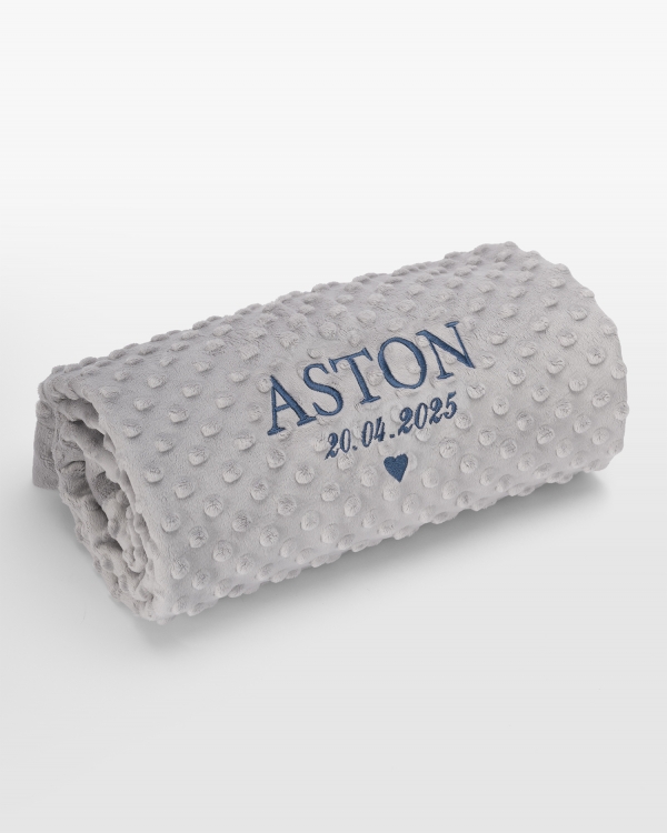 Harmaa vauvanpeitto sinisellä nimikirjonnalla