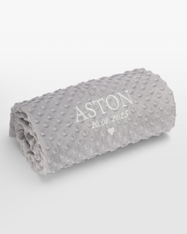 Harmaa peitto valkoisella nimibrodeerauksella