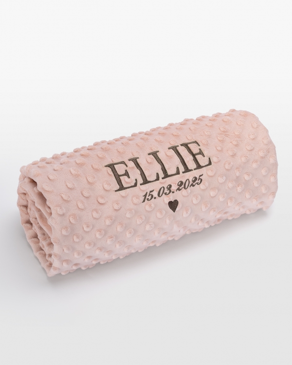 Vaaleanpunainen vauvanpeitto, jossa on personoitu lämmin harmaa nimibrodeeraus. Täydellinen ihanan kodikkaaseen ja mukavaan tunn