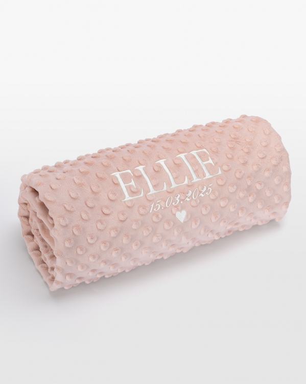 Vaaleanpunainen vauvanpeitto nimellä valkoisella brodeerauksella