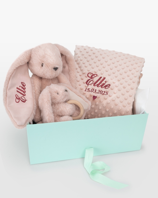Henkilökohtainen lahjapaketti vauvalle, jossa on pehmolelu, vauvan viltti ja pehmolelu purulelulla.