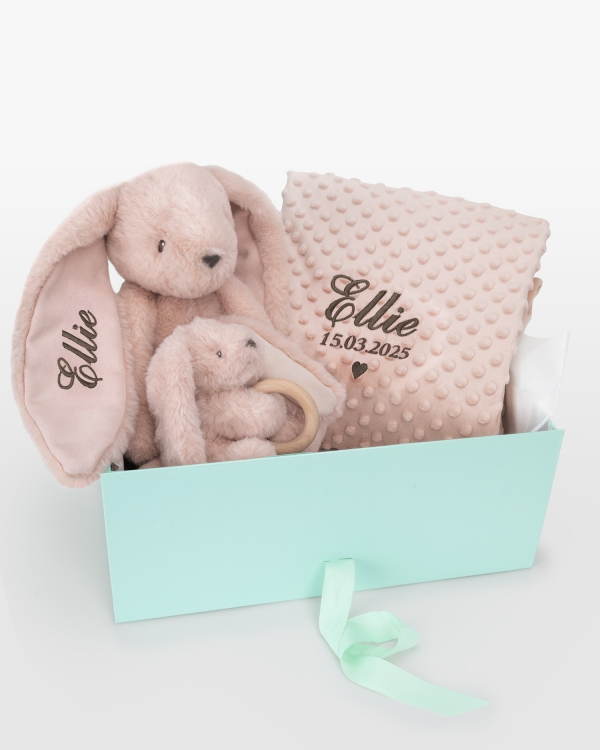 Henkilökohtainen lahjapaketti vauvalle, jossa on pehmolelu, vauvan viltti ja pehmolelu purulelulla.