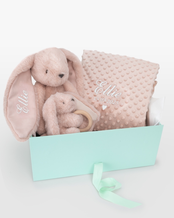 Henkilökohtainen lahjapaketti vauvalle, jossa on pehmolelu, vauvan viltti ja pehmolelu purulelulla.