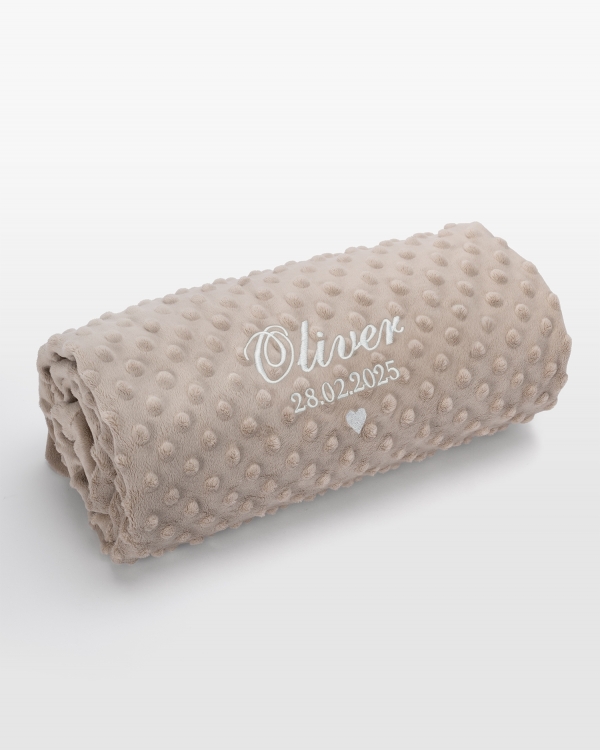 Hiekkavärinen vauvanpeitto nimellä valkoisella brodeerauksella