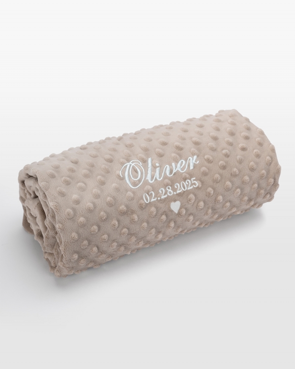 Hiekkavärinen vauvanpeitto nimellä valkoisella brodeerauksella