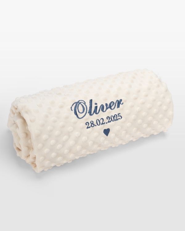 Kermanvärinen vauvanpeitto sinisellä brodeerauksella