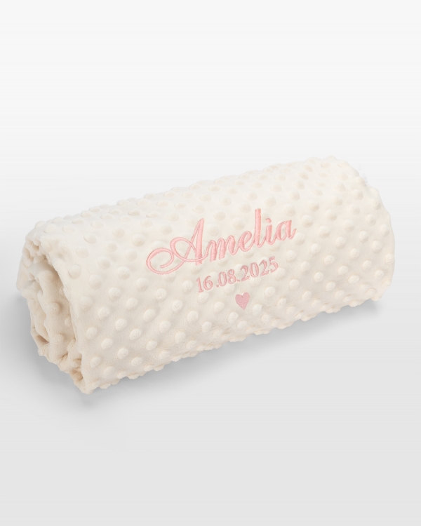 Kermanvärinen vauvanpeitto vaaleanpunaisella nimikirjonnalla