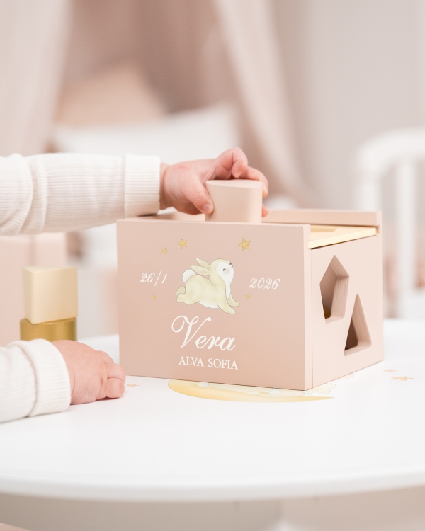 Vaaleanpunainen puinen lajittelulaatikko henkilökohtaisella merkinnällä