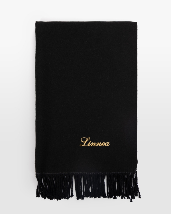 Musta kaulahuivi henkilökohtaisella kultakirjonnalla, täydellinen ylelliseen tyyliin ja lämpimään talviyöhön.