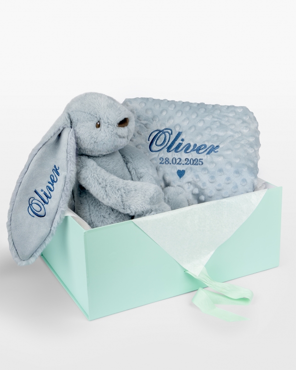 Vauvalahjasetti, jossa sininen pehmopupu ja pehmeä viltti, johon on kirjailtu nimi ja päivämäärä