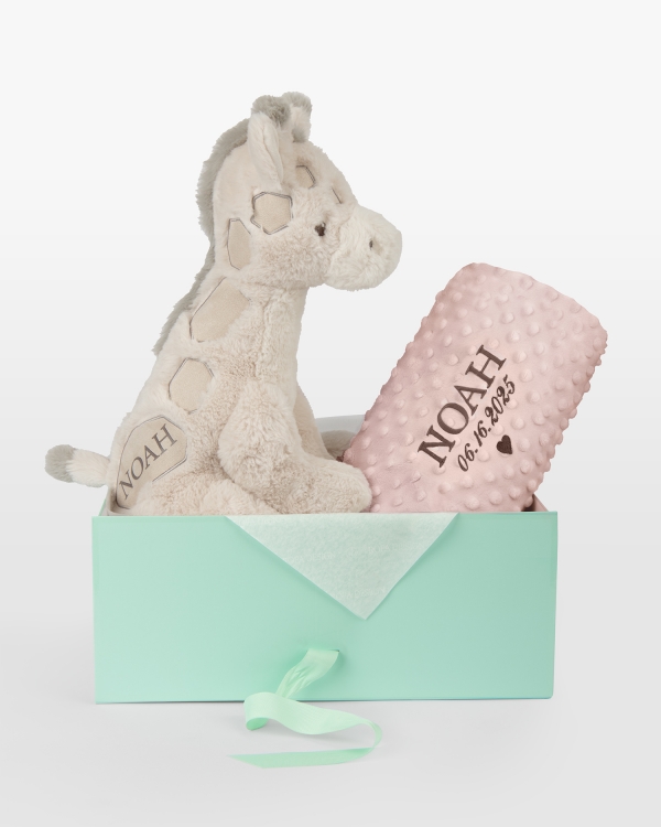 Pehmeä vaaleanpunainen peitto, jossa on kirjailtu nimi ja päivämäärä