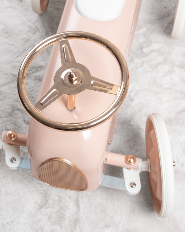 vaaleanpunainen potkuauto nimellä