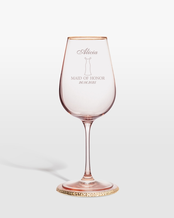 Vaaleanpunainen viinilasi, johon kaiverretaan kaason nimi