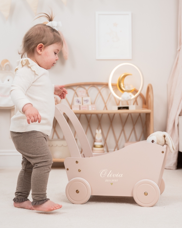 Vaaleanpunainen puinen nukkevagn nimellä