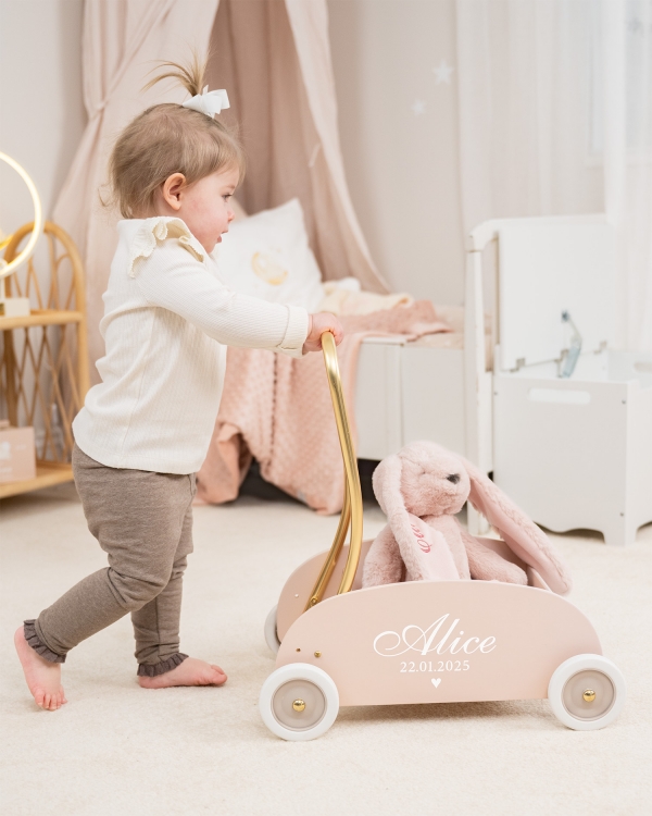 Vaaleanpunainen kävelyteline nimellä ja syntymäpäivällä