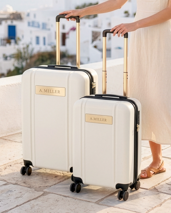 Kermanvärinen matkalaukku ja käsimatkatavaralaukku, joissa on kaiverrettu nimi