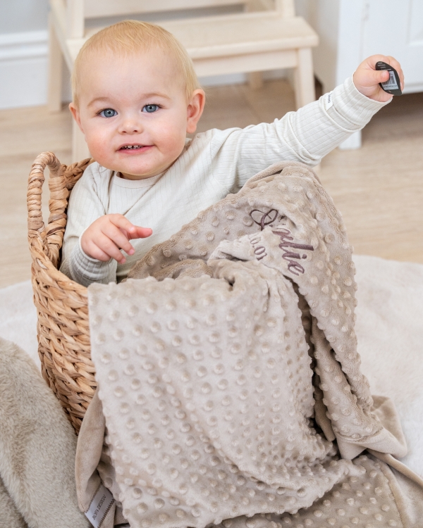 vauvan peitto, jossa on kirjailtu nimi ja syntymäpäivä