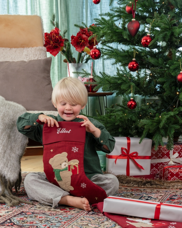 Punainen joulusukka eläinkuviolla ja henkilökohtaisella brodeerauksella