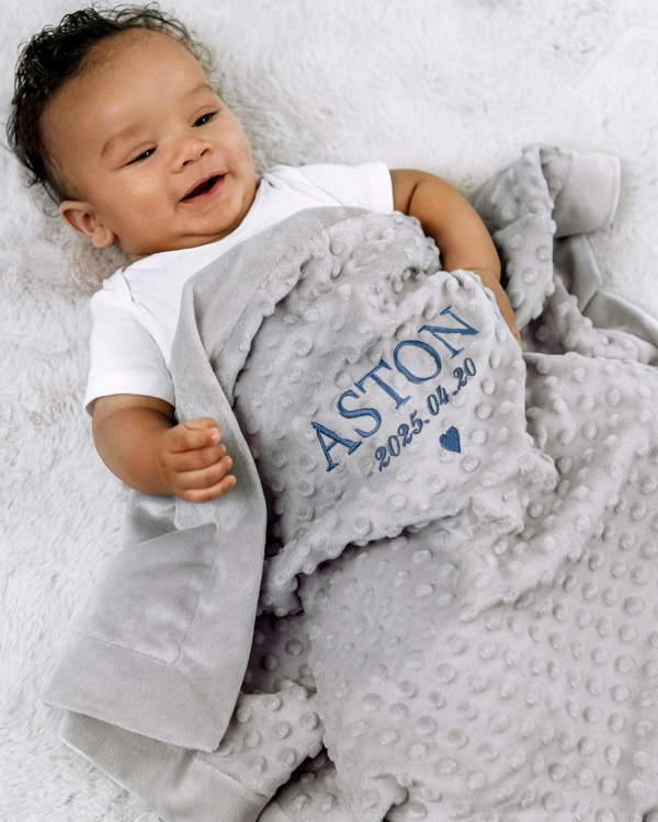 Pehmeä harmaa vauvanpeitto kirjailtulla nimellä