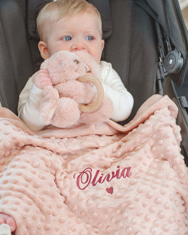 Pehmeä vauvanpeitto, joka toimitetaan henkilökohtaisella merkinnällä ja yhteensopivalla pehmolelulla, jossa on pururengas