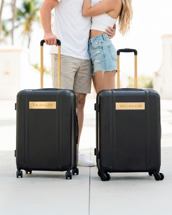 Musta matkalaukku, johon on kaiverrettu nimi