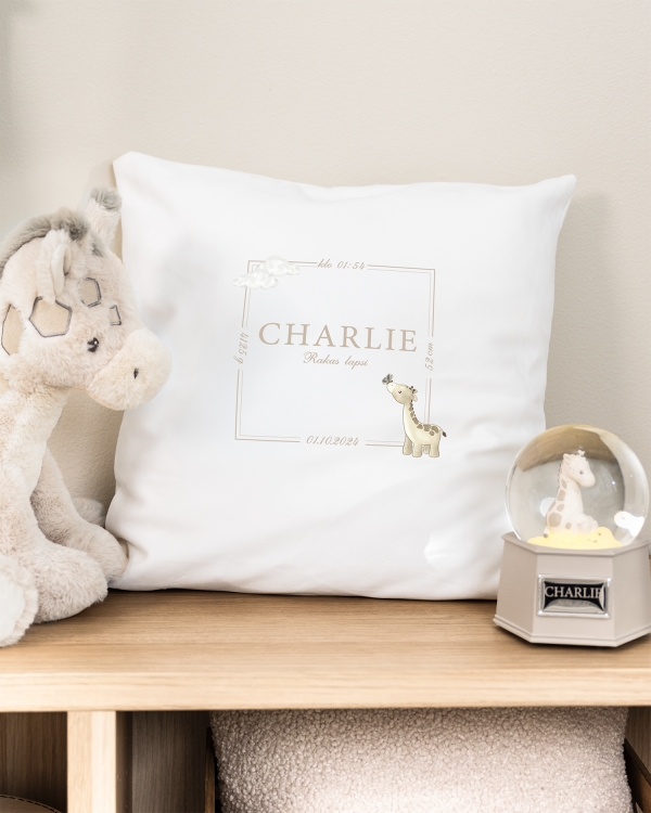 Valkoinen tyynyliina, jossa on painettu kirahviaihe sekä nimi ja päivämäärä
