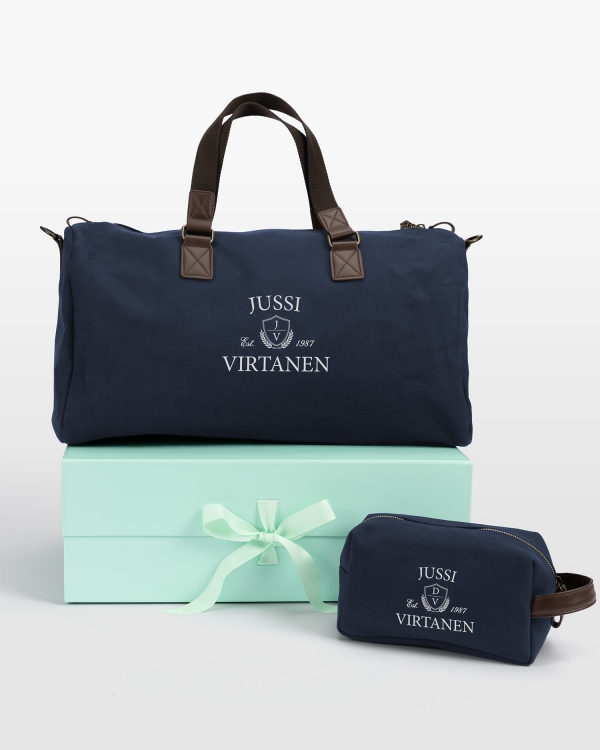 tummansininen setti, jossa on meikkilaukku ja nimilapulla varustettu matkakassi