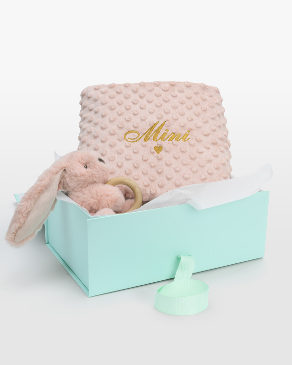 Lahjasetti, jossa on purulelulla varustettu pehmolelu ja nimellä varustettu peitto