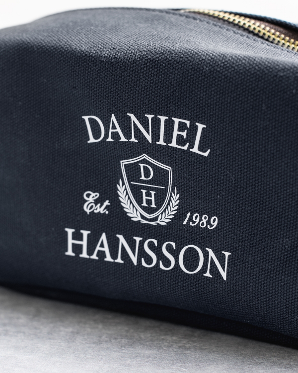 Tummansininen meikkilaukku nimellä